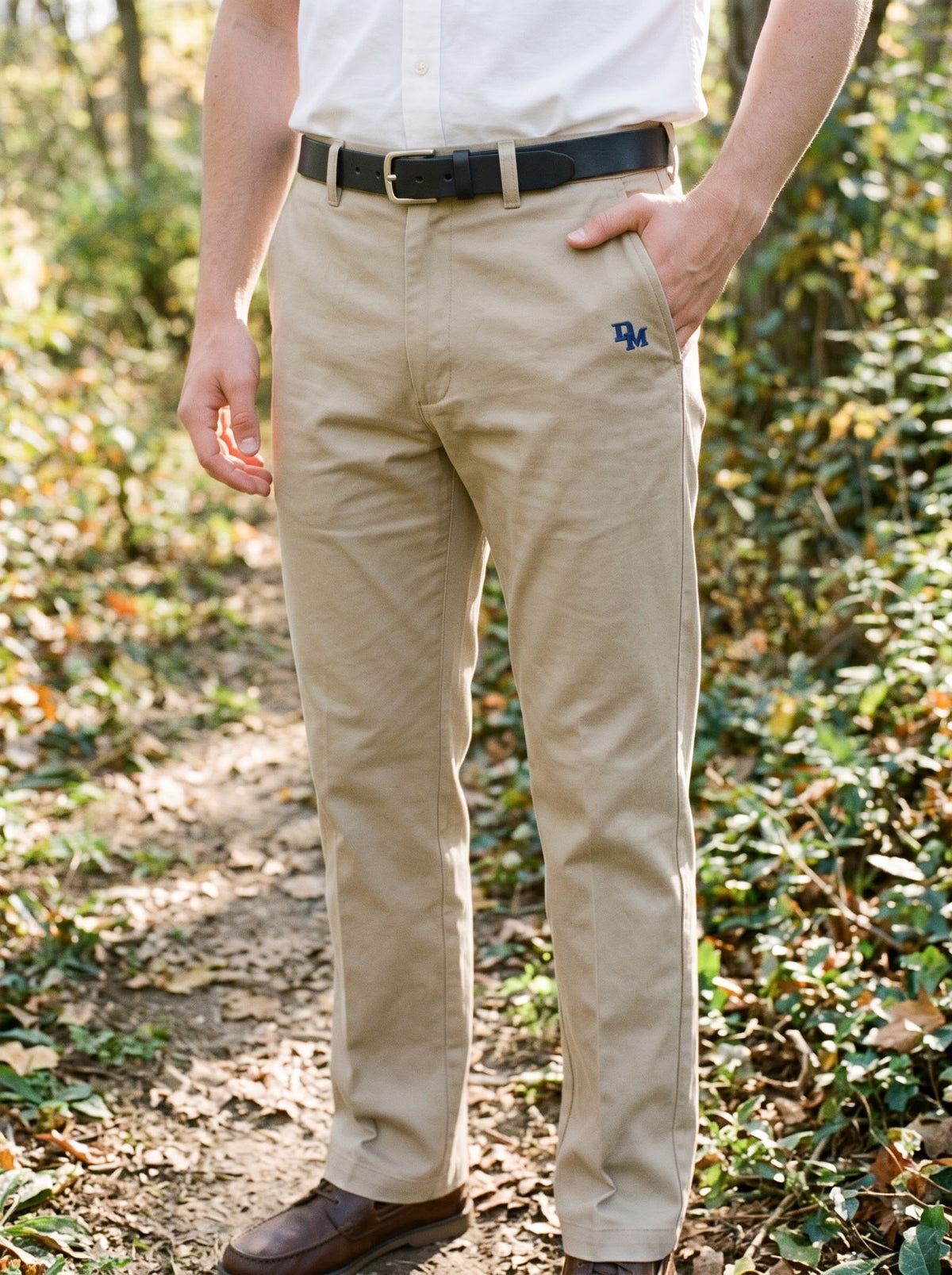 Student wearing khaki DeMatha logo pants with a black belt