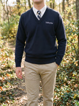 Load image into Gallery viewer, Student wearing the navy DeMatha V-neck sweater over an oxford and tie