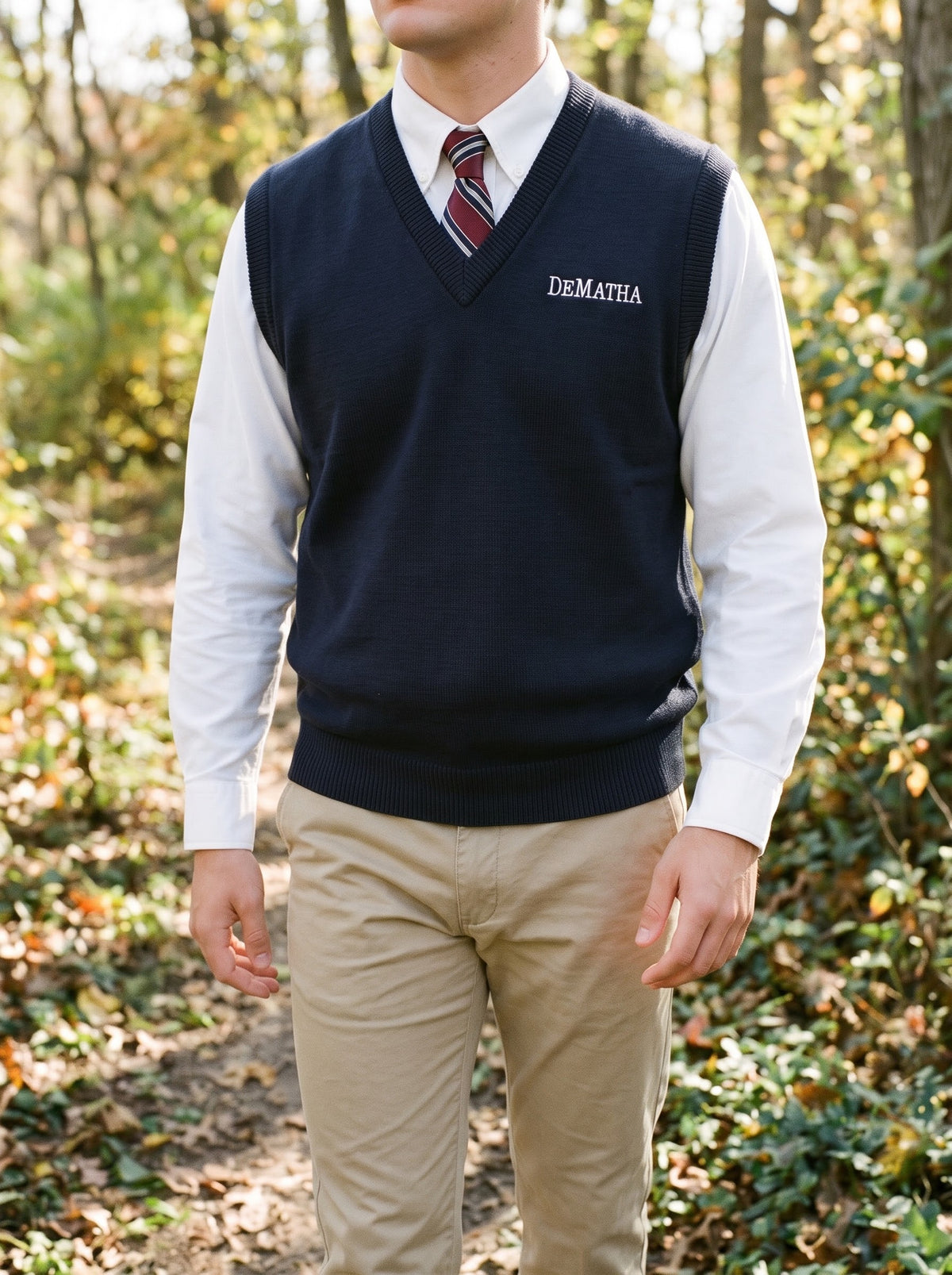Student wearing the navy DeMatha sweater vest over a white oxford and tie
