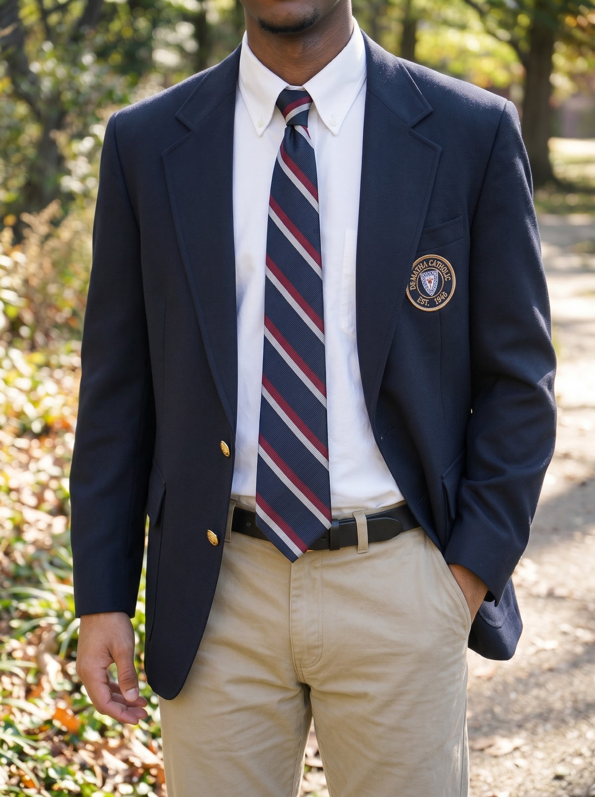 Student wearing the navy, burgundy and silver striped tie with a navy blazer